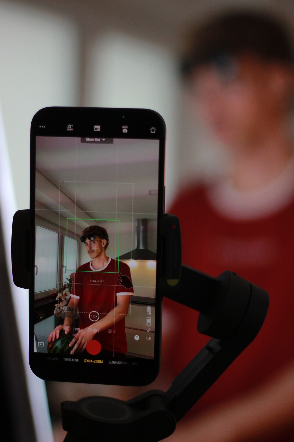 Pessoa gravando a si mesma com o celular em um ambiente interno silencioso.