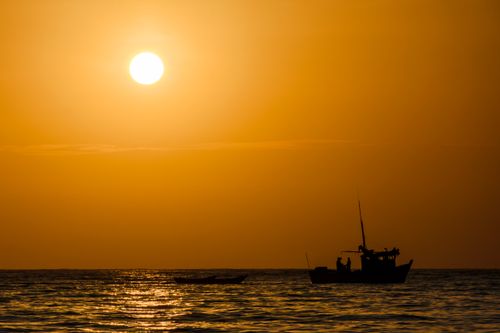 Free A stunning sunset view with a boat silhouette in Máncora, Peru. Vibrant and dramatic. Stock Photo