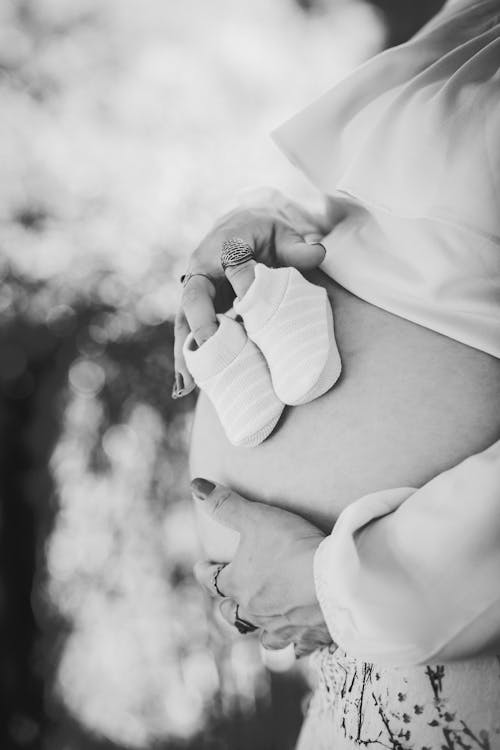 бесплатная Фотография беременного живота в оттенках серого Стоковое фото