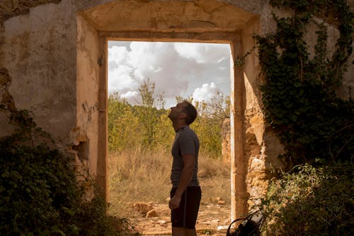 Ücretsiz adam, dışarı bakmak, terk edilmiş bina içeren Ücretsiz stok fotoğraf Stok Fotoğraflar