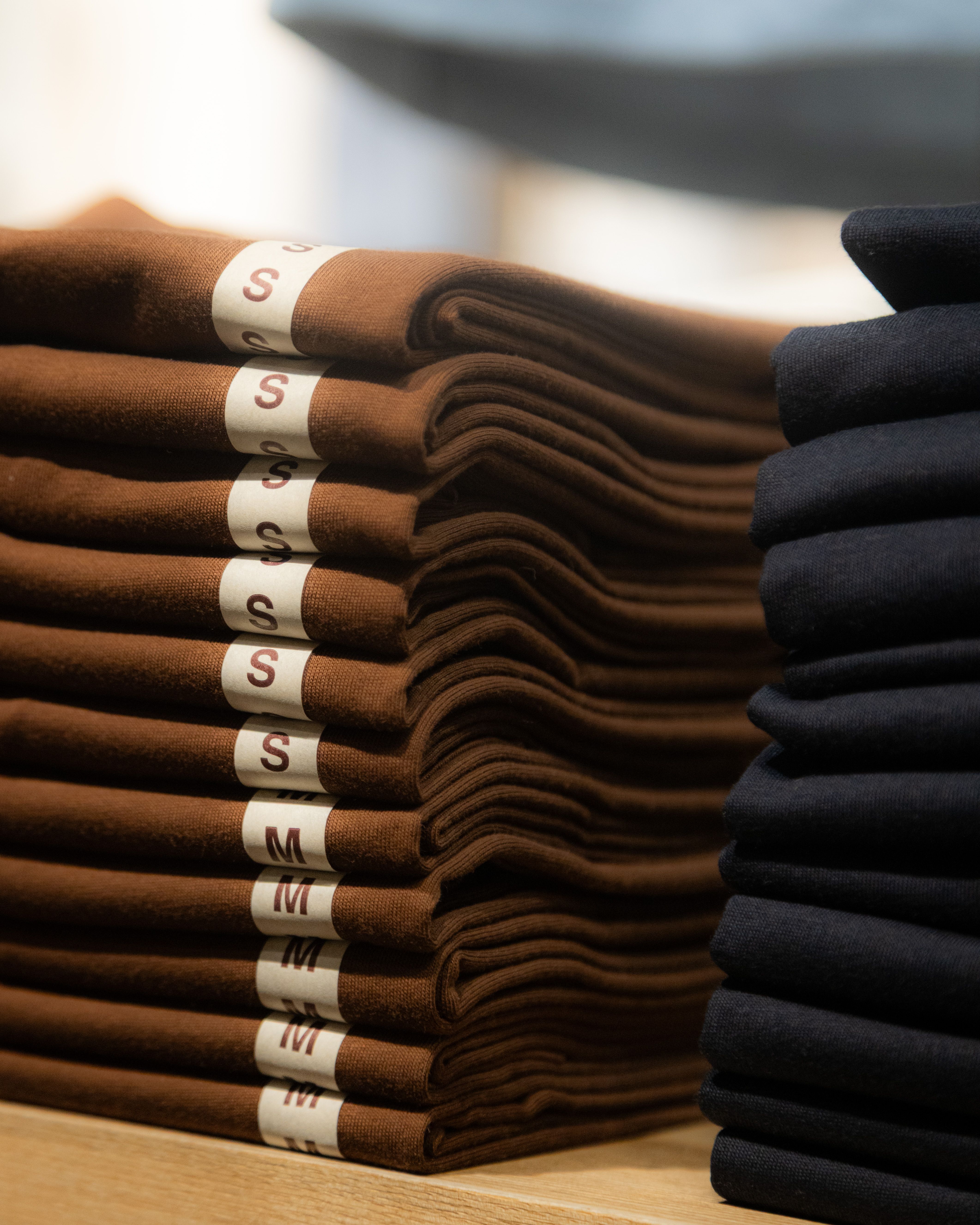 Neatly folded brown and black shirts in a retail store in Hà Nội, Vietnam.