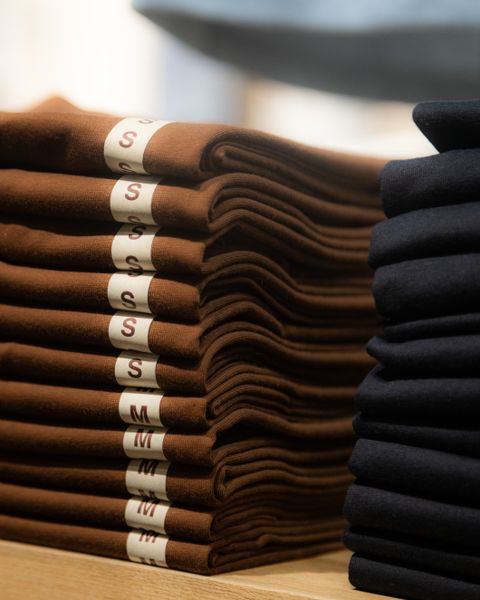Folded brown and black overshirts on a store shelf