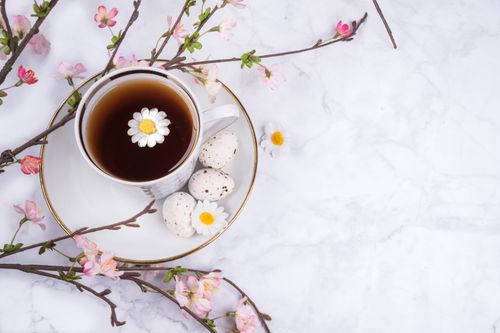 Free Cup of tea with cherry blossoms and Easter eggs on marble surface. Stock Photo