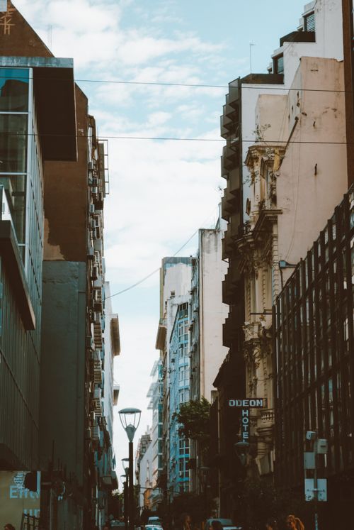Free City street lined with modern and historic buildings under a blue sky. Stock Photo