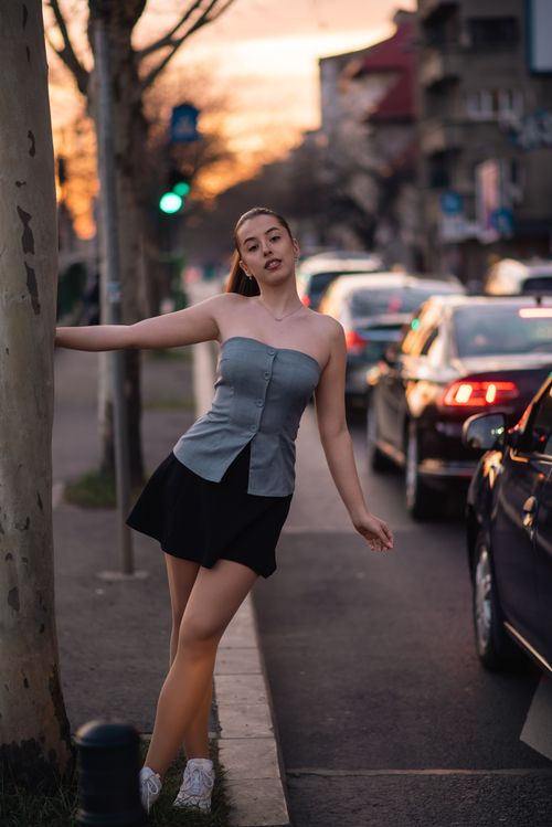 Free Portrait of a young woman in a Romanian city street, captured at sunset. Urban, stylish, modern. Stock Photo