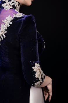 A close-up of a luxurious velvet evening gown featuring intricate floral embroidery.