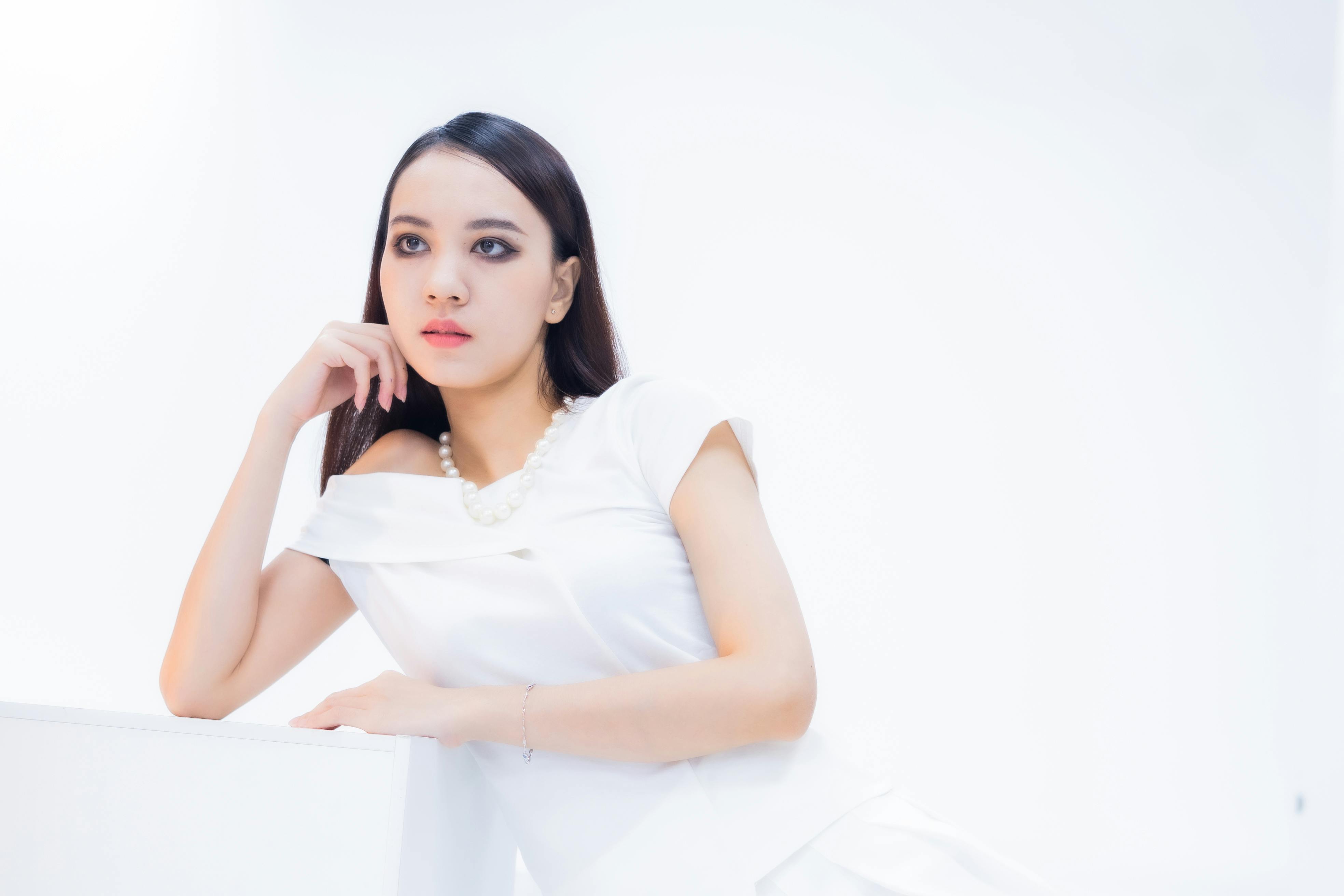 Miễn phí Chân dung thanh lịch của một người phụ nữ trong chiếc váy trắng, toát lên vẻ duyên dáng và phong cách với tư thế thanh thản. Ảnh lưu trữ