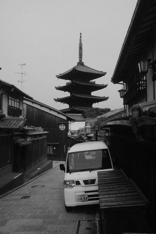 Free A serene view of a Kyoto pagoda with a modern car, blending tradition and modernity. Stock Photo