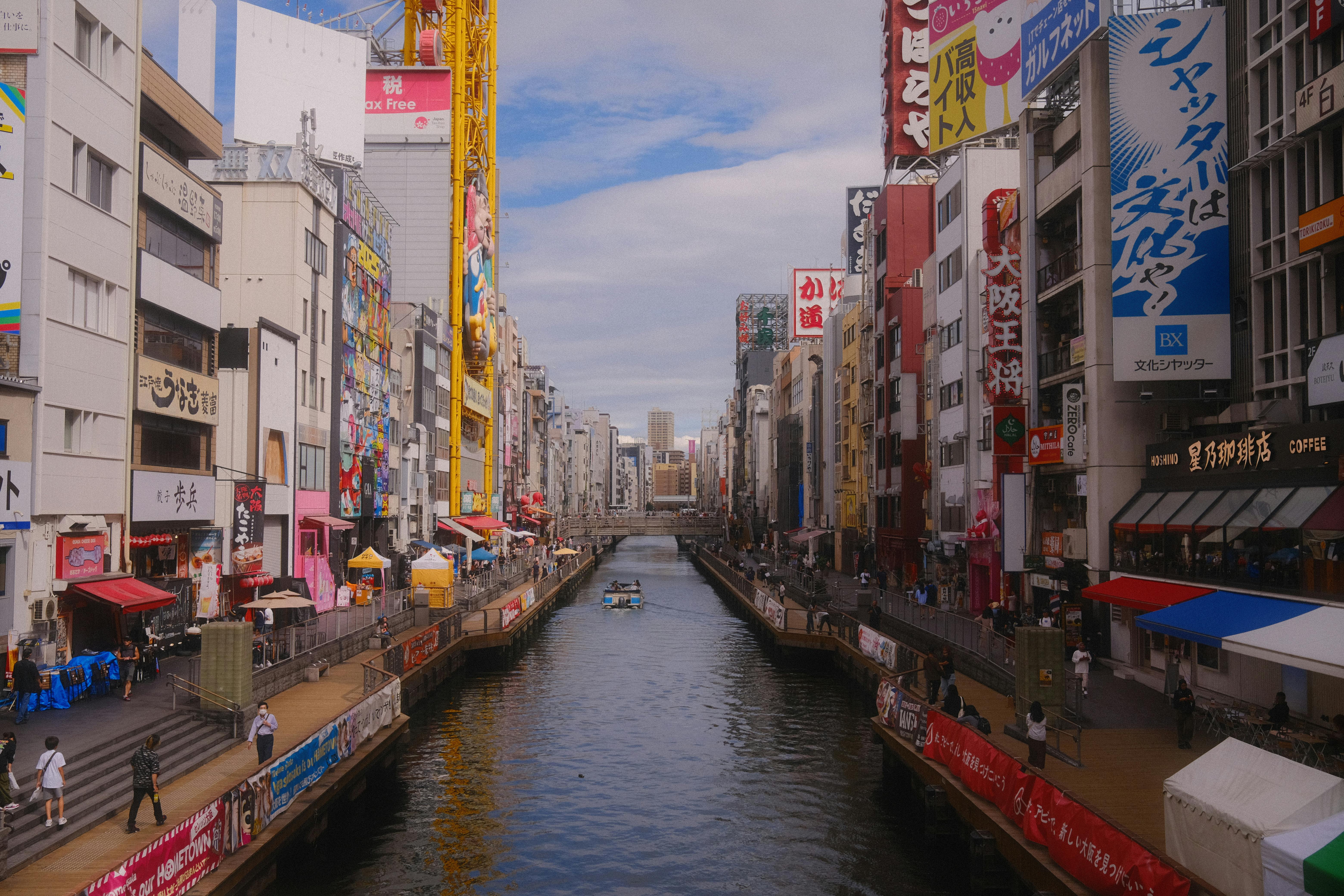 Colorful buildings line the bustling Dotonbori Canal in Osaka, Japan.