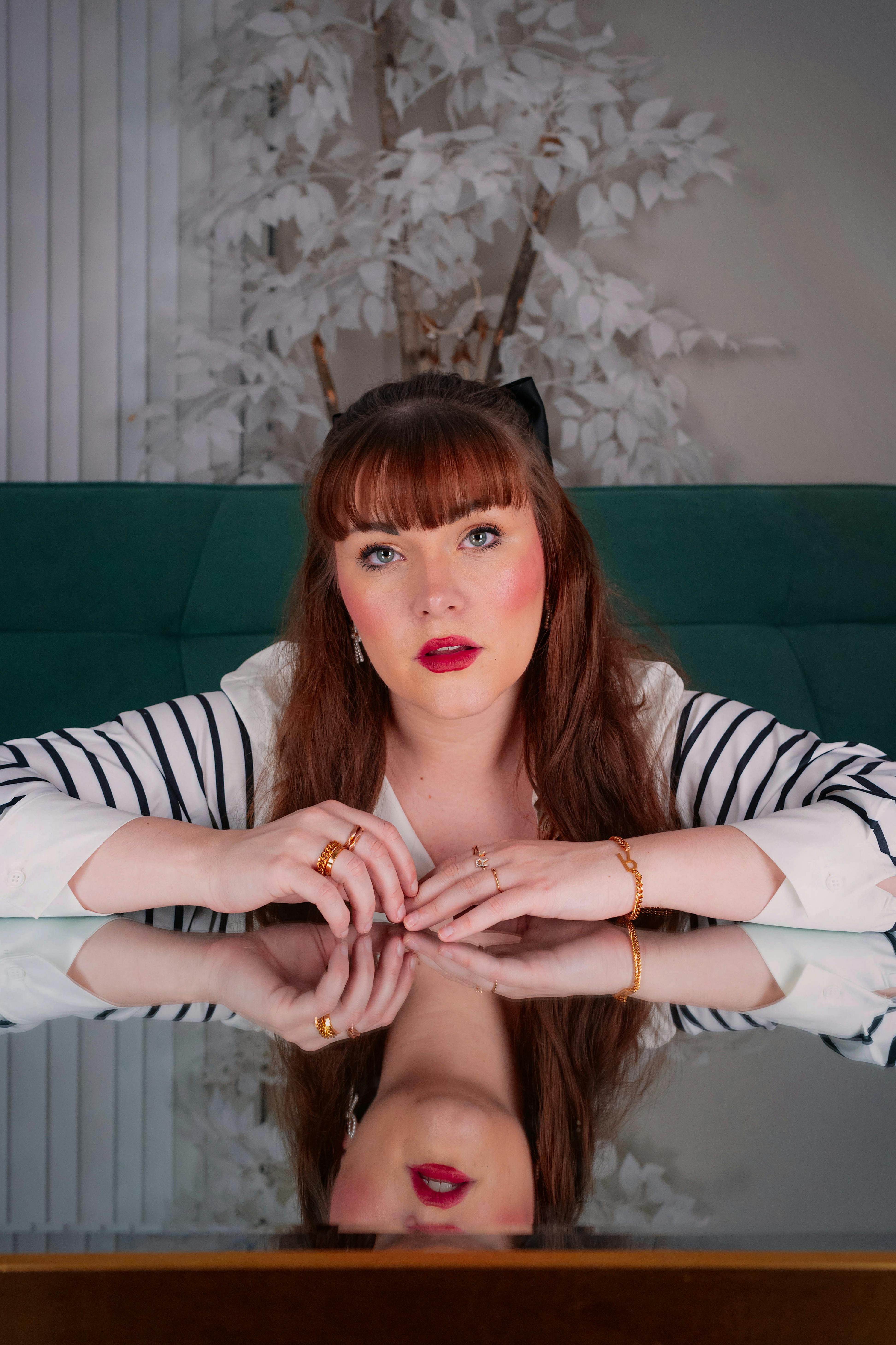 Artistic portrait of a woman with mirror reflection in an indoor setting.