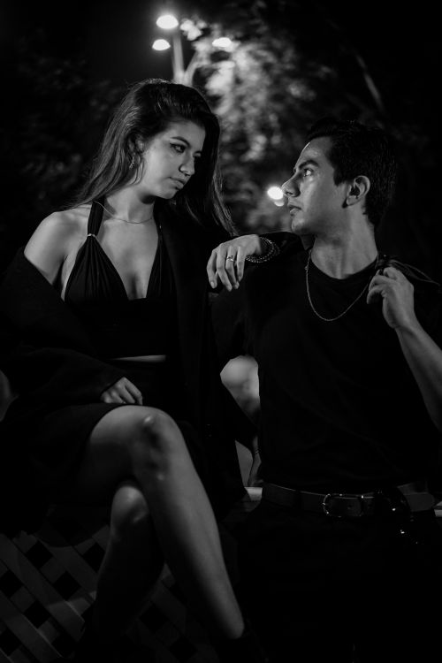 Free Stylish couple poses elegantly in a captivating black and white nighttime portrait, exuding classic charm. Stock Photo