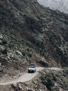 A 4x4 vehicle traverses a rugged mountain road, capturing the essence of adventure travel.