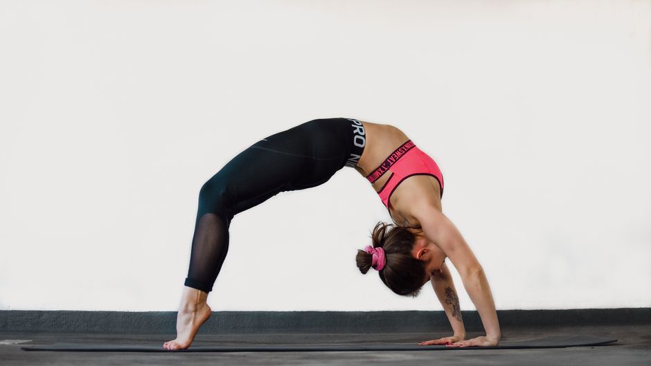 A person performing the yoga Bridge Pose, expanding their chest and lungs A person performing the yoga Bridge Pose, expanding their chest and lungs