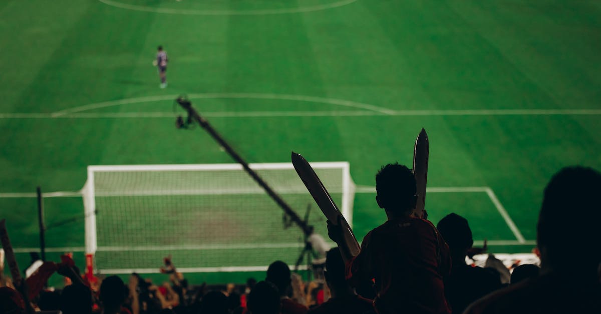 Fans cheer during a thrilling football match as the players engage intensely on the field.