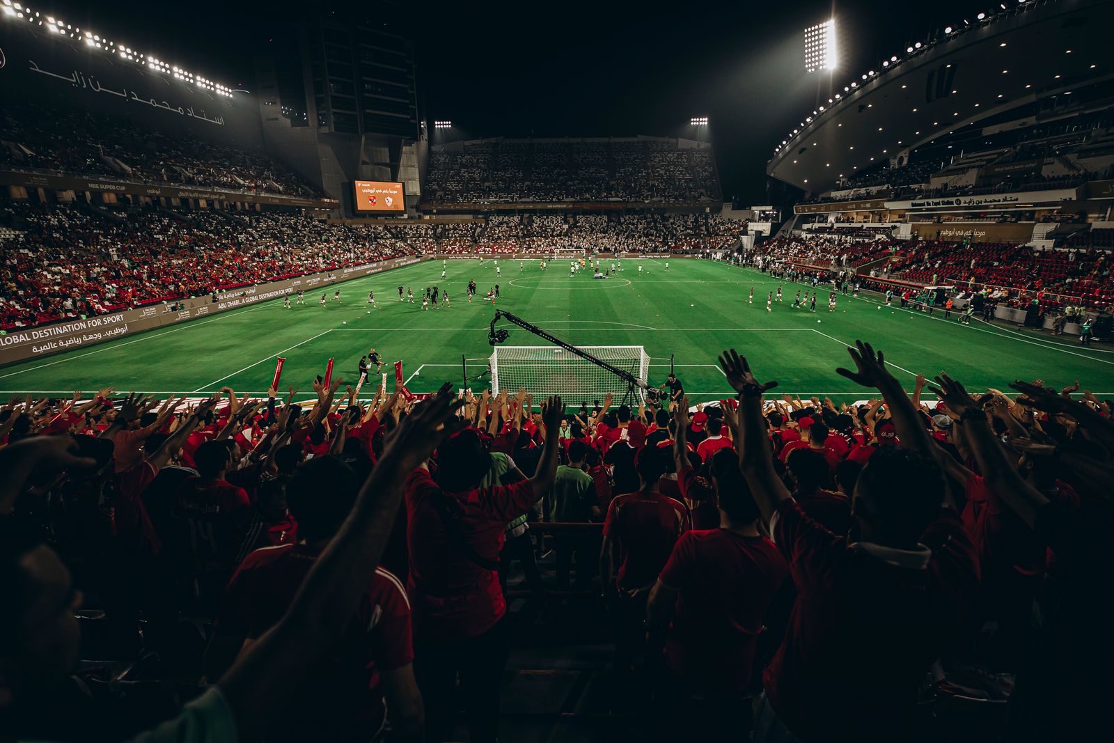Supporters with raised arms in the stand on a match night