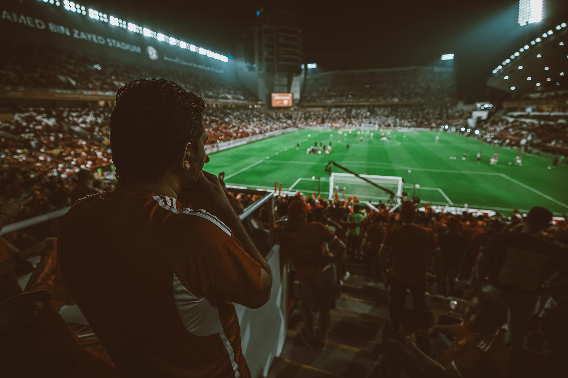 Fans cheering during a thrilling night football match at Mohamed Bin Zayed Stadium, Abu Dhabi.