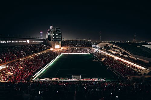 Free A vibrant nighttime aerial view of a football match at Mohammed Bin Zayed Stadium in Abu Dhabi. Stock Photo
