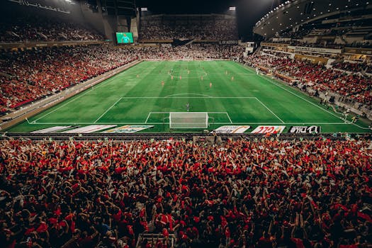 A thrilling nighttime football match with a vibrant crowd in Abu Dhabi stadium.