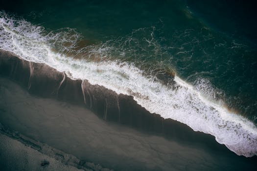 这是一张宁静的航拍照片，海浪轻拍沙滩，风景如画