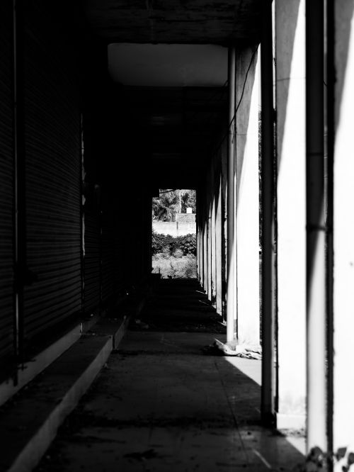 Free Black and white photo of an urban corridor with dramatic shadows and depth. Stock Photo