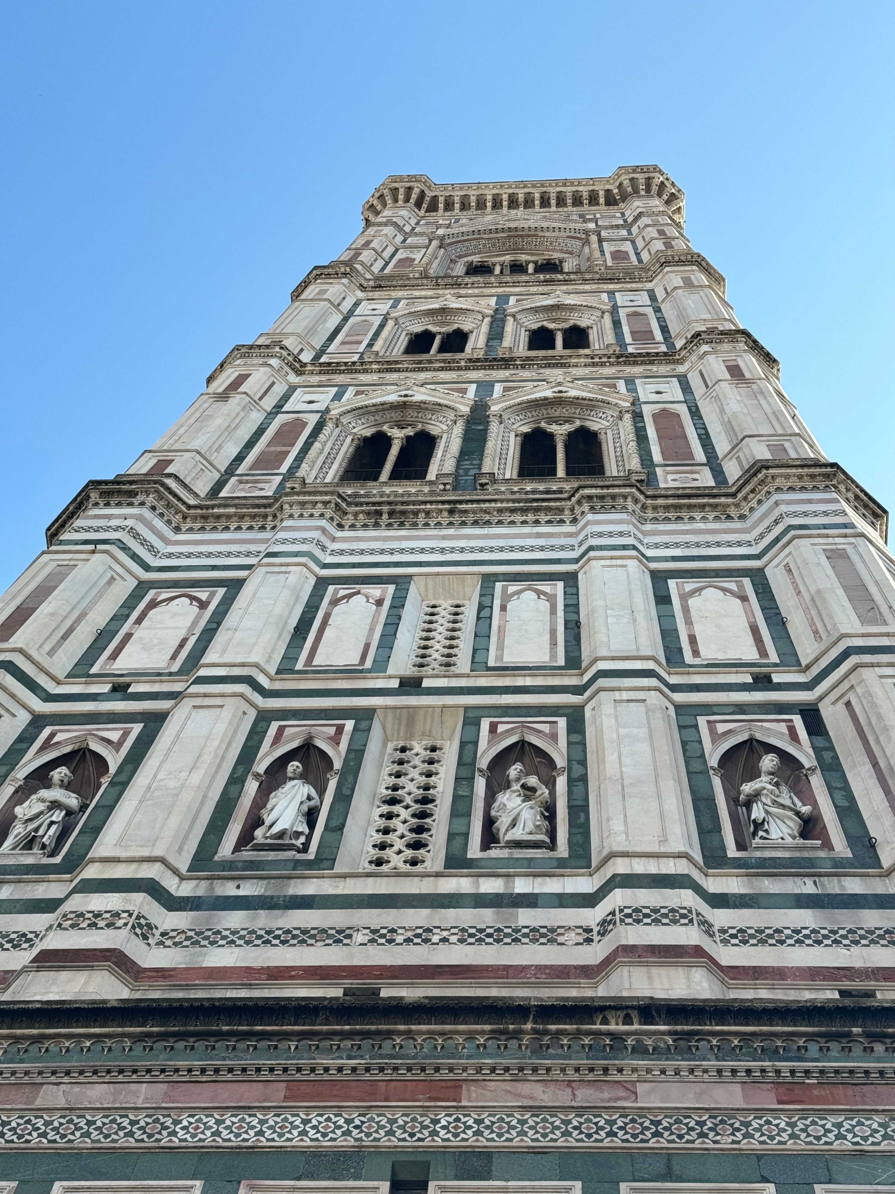 A majestic upward view of Giotto's Campanile, showcasing its intricate Gothic architecture in Florence.