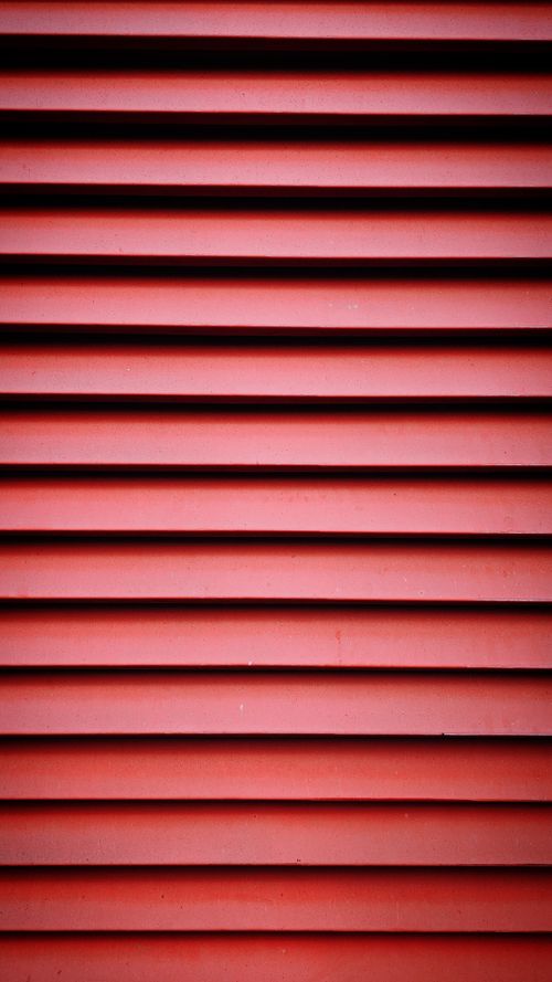 Free Abstract pattern of red metal louvers creating a visually striking texture. Stock Photo