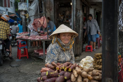 在胡志明市的街头市场，一名越南妇女微笑着卖蔬菜