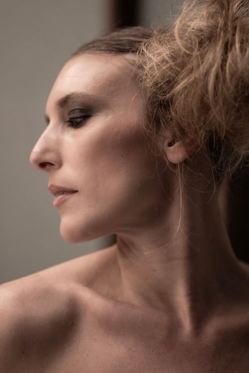 Free Striking side profile portrait of a woman with elegant hairstyle and soft makeup in ambient lighting. Stock Photo