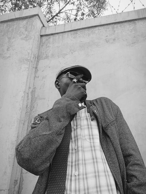Free Monochrome photo of a stylish man smoking outdoors, expressing attitude. Stock Photo