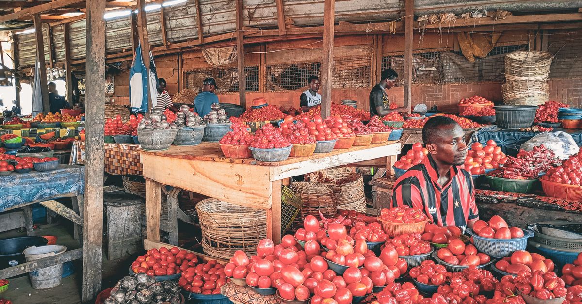 Local market scene with colorful textiles and fresh produce in Kpetoe