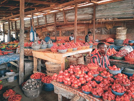 Colorful display of fresh produce at an African street market, featuring various vegetables and local vendors.