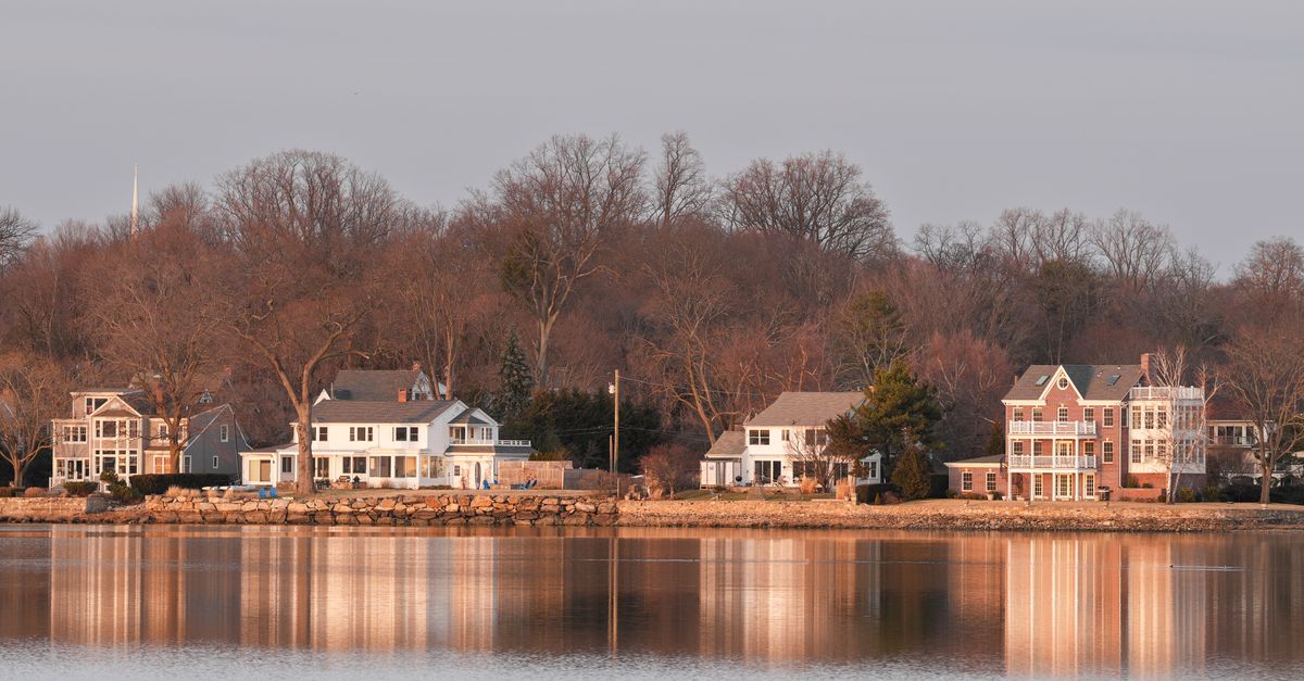 Beautiful waterfront homes in Stamford, Connecticut at twilight reflecting over calm water.