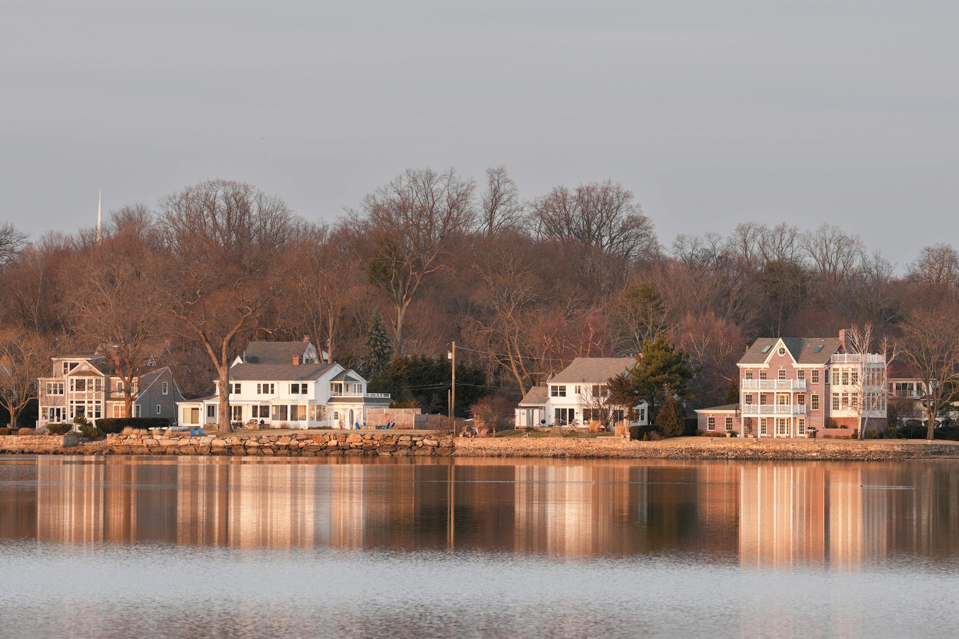 Beautiful waterfront homes in Stamford, Connecticut at twilight reflecting over calm water.