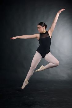 Graceful ballet dancer in motion captured mid-leap, showcasing elegance and discipline.