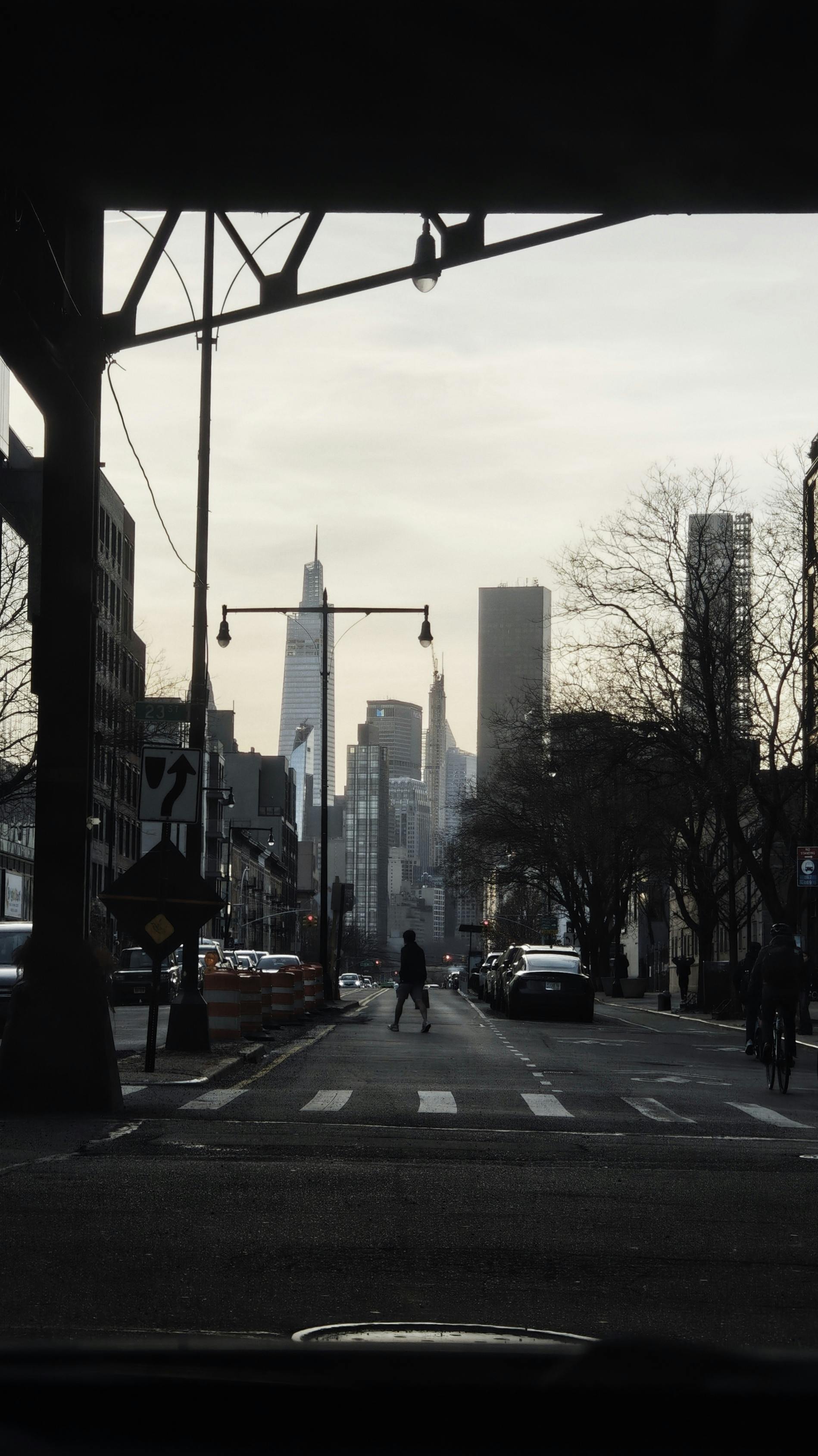 Urban street scene with a distant skyline and pedestrian crossing at dusk.