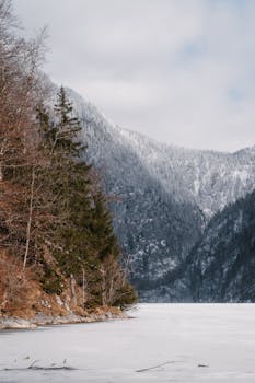 Majestic winter scene featuring a frozen lake and snow-capped mountains.