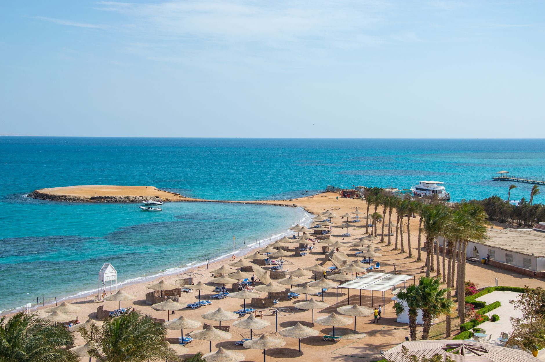 Idyllic beach scene with rows of umbrellas and azure ocean, perfect for travel and relaxation themes.