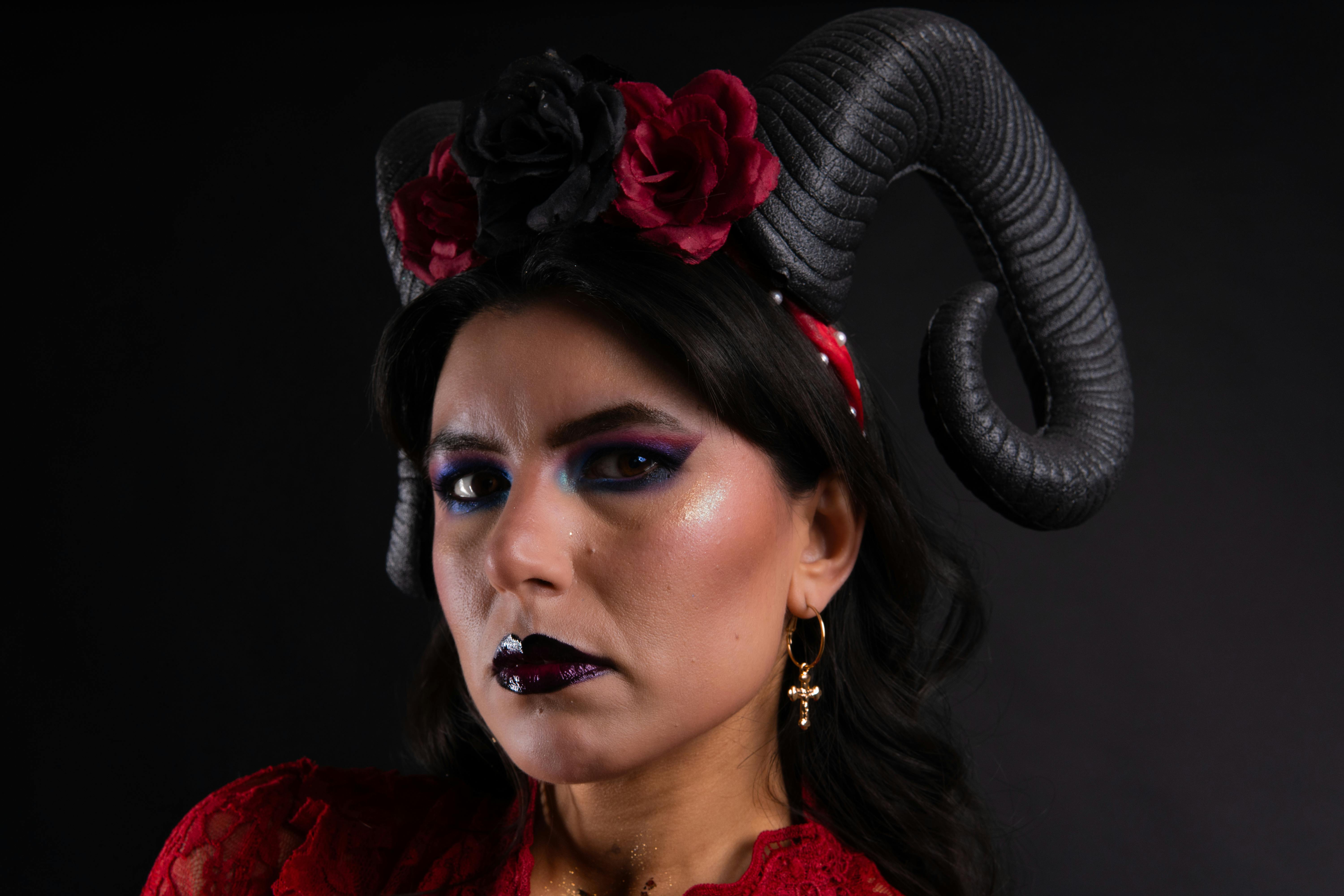 Gratuit Portrait de mode éditorial mettant en vedette une femme en robe rouge avec des cornes noires et une coiffe florale. Photos