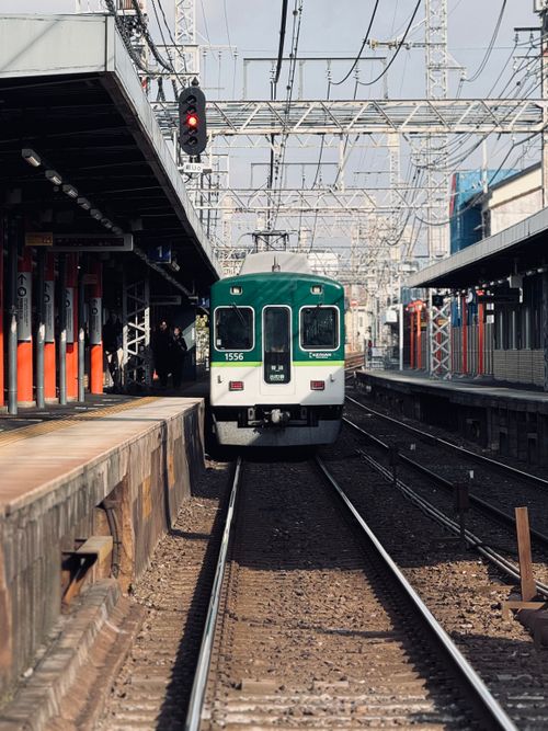 Free A commuter train arriving at an empty Japanese railway station on a sunny day. Stock Photo