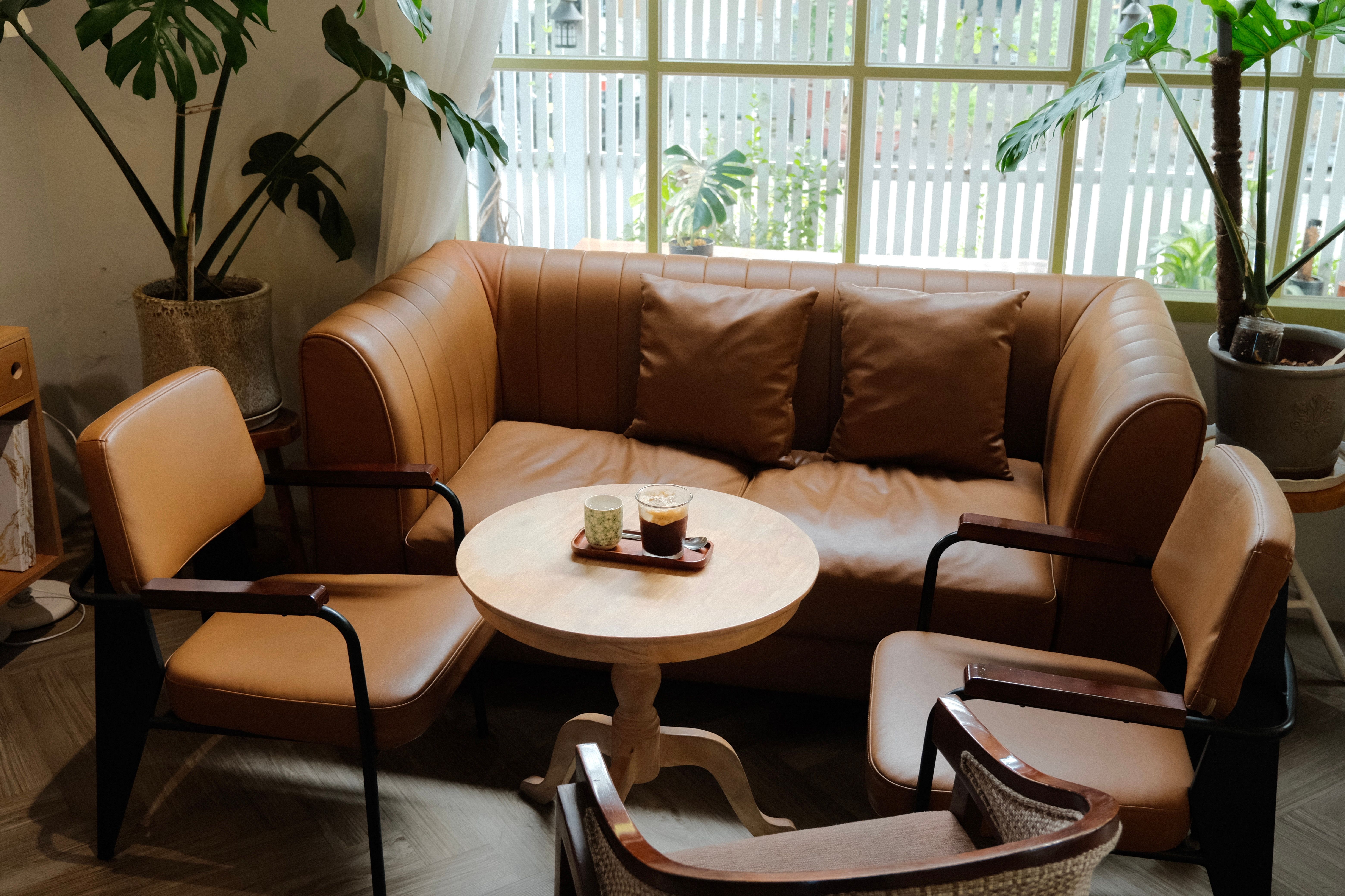 A cozy seating area with leather furniture and coffee under natural light.