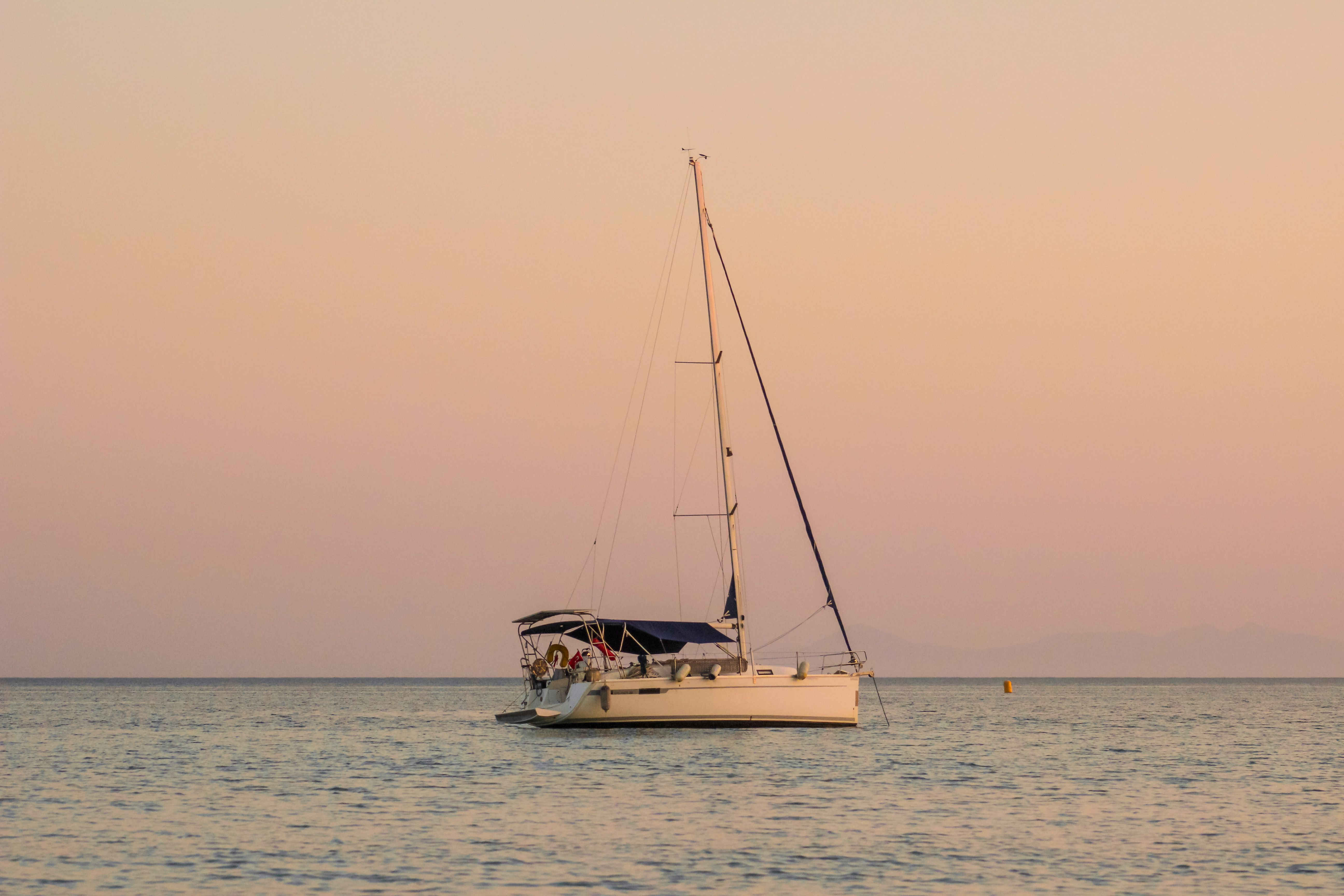 Sailboat at Sunset on a Calm Sea · Free Stock Photo