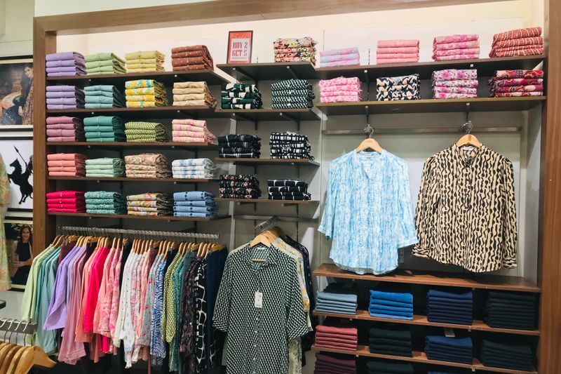 Vivid display of neatly arranged clothes and fabrics in a retail store.