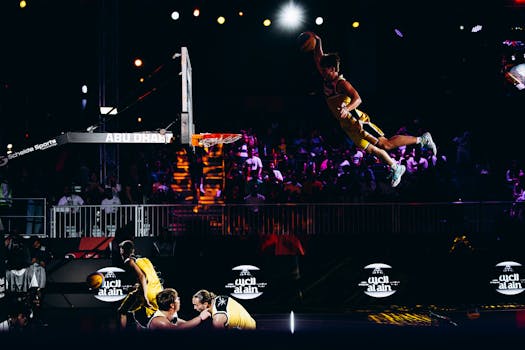 Basketball player performing an impressive slam dunk during an Abu Dhabi sports event.
