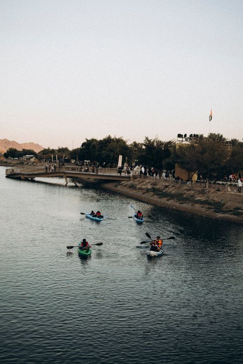 Free Kayakers enjoy a serene adventure in Hatta, Dubai by the tranquil waters during sunset. Stock Photo