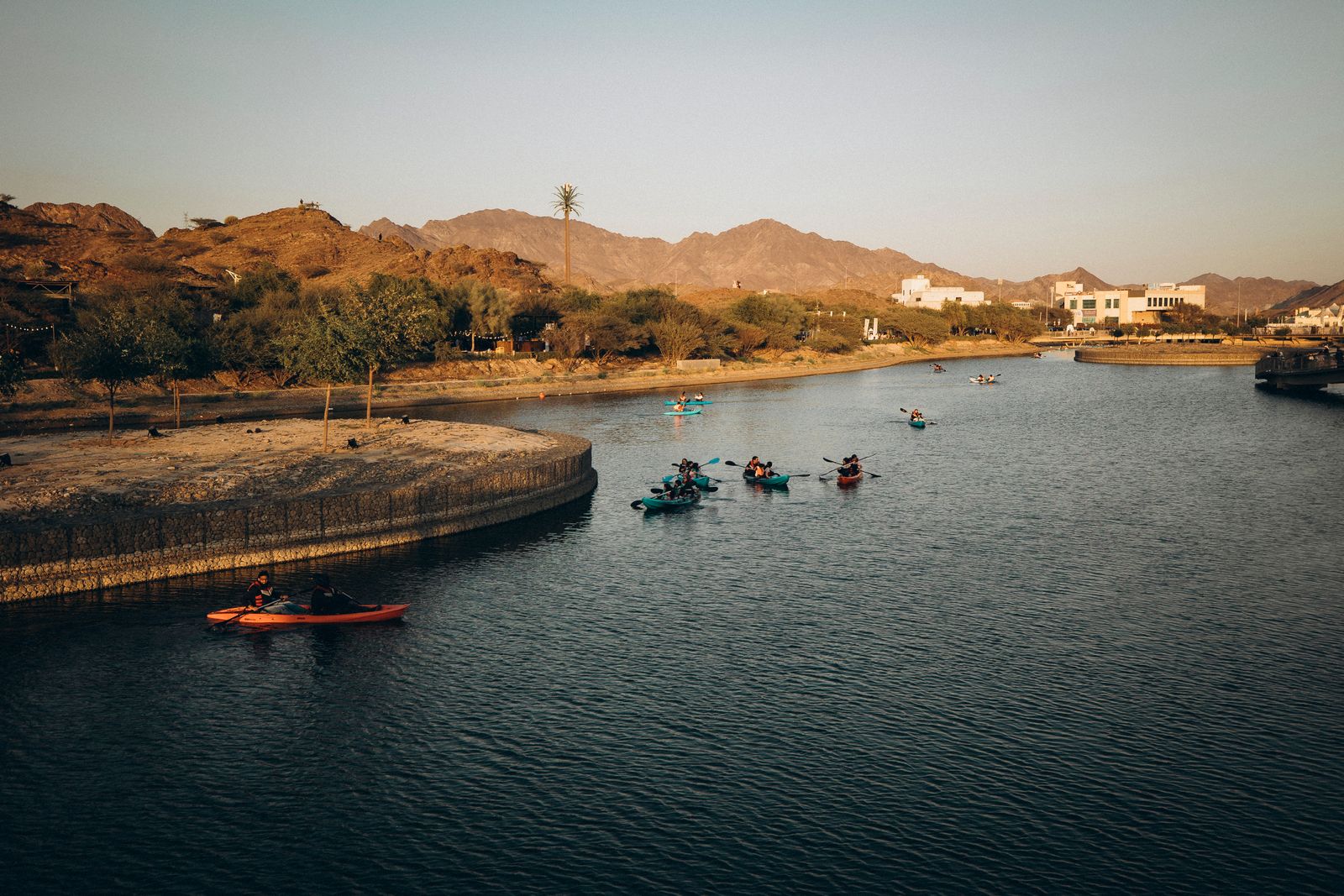 Kayakers paddling on calm water in Hatta, with mountains in the background