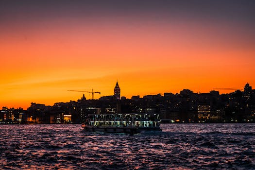 伊斯坦布尔的天际线上，日落充满活力，博斯普鲁斯海峡上渡轮穿梭，建筑轮廓鲜明