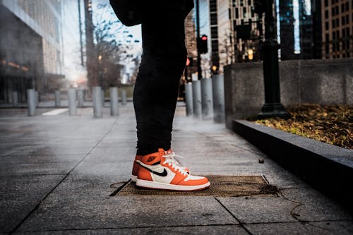 Pair of White-and-orange Nike Sneakers