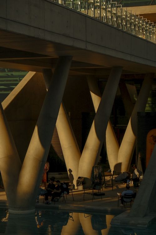 Free Silhouettes under a modern architectural bridge in warm light. Stock Photo