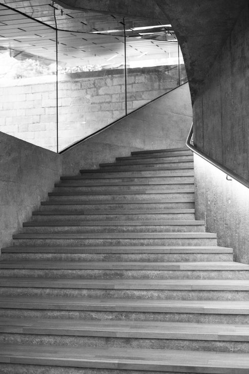 Free Black and white photo of a modern curved staircase in Hong Kong, showcasing architectural beauty. Stock Photo