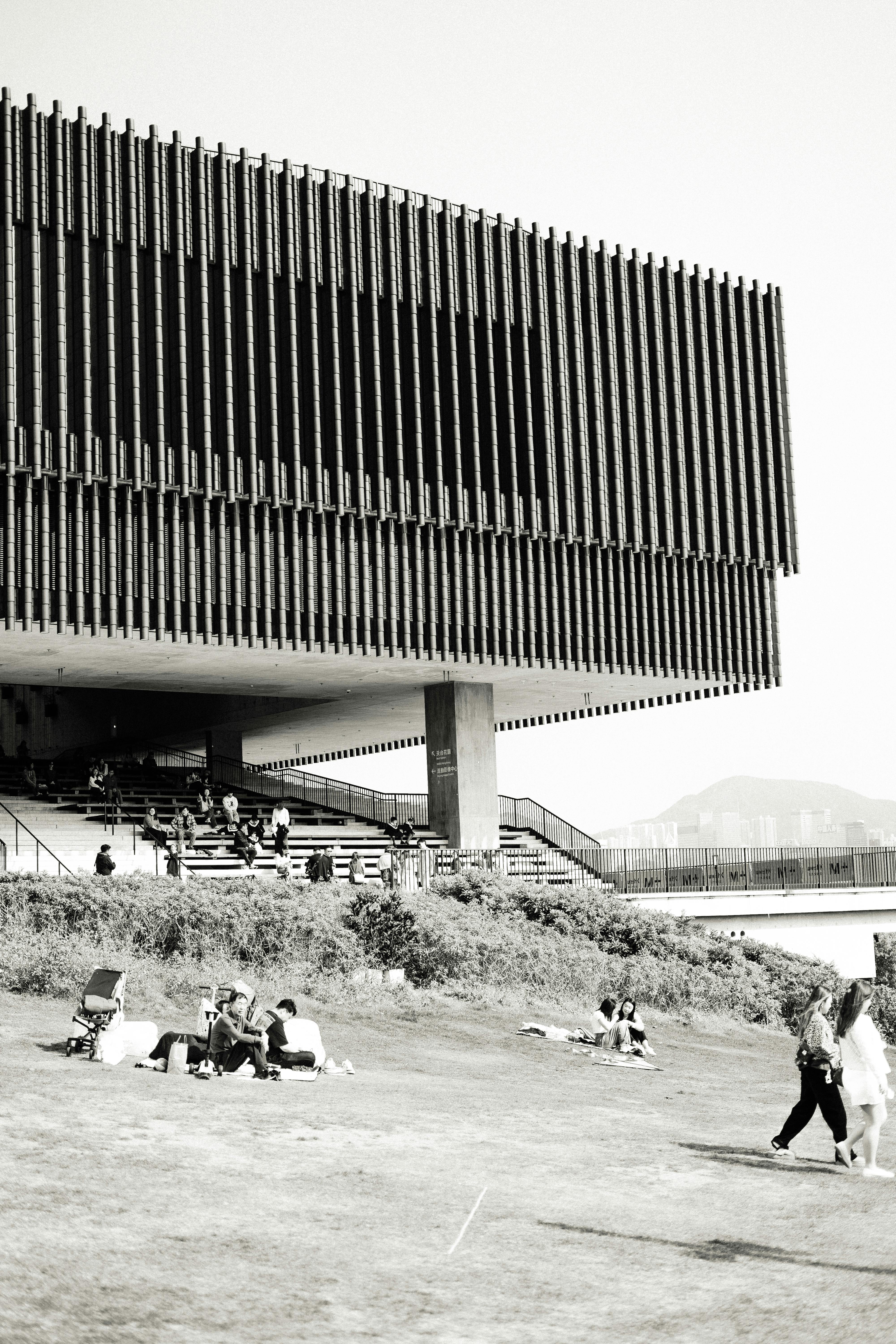 Black and white photo capturing modern architecture in Kowloon's urban park setting.